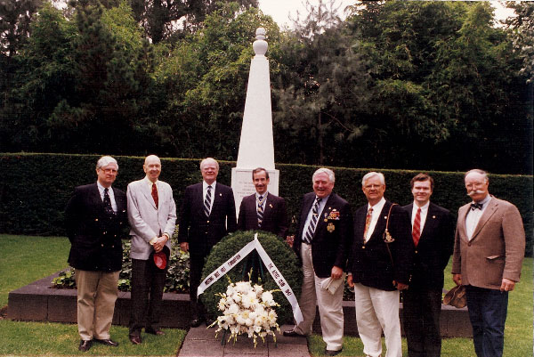 Members standing before monument